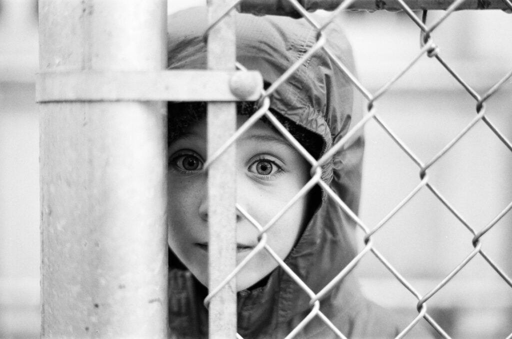 Boy standing in front of fence