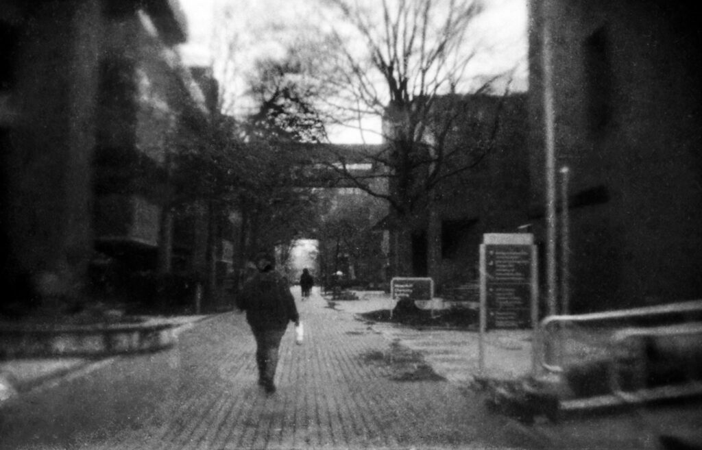 Person walking in rain between academic building at UMBC