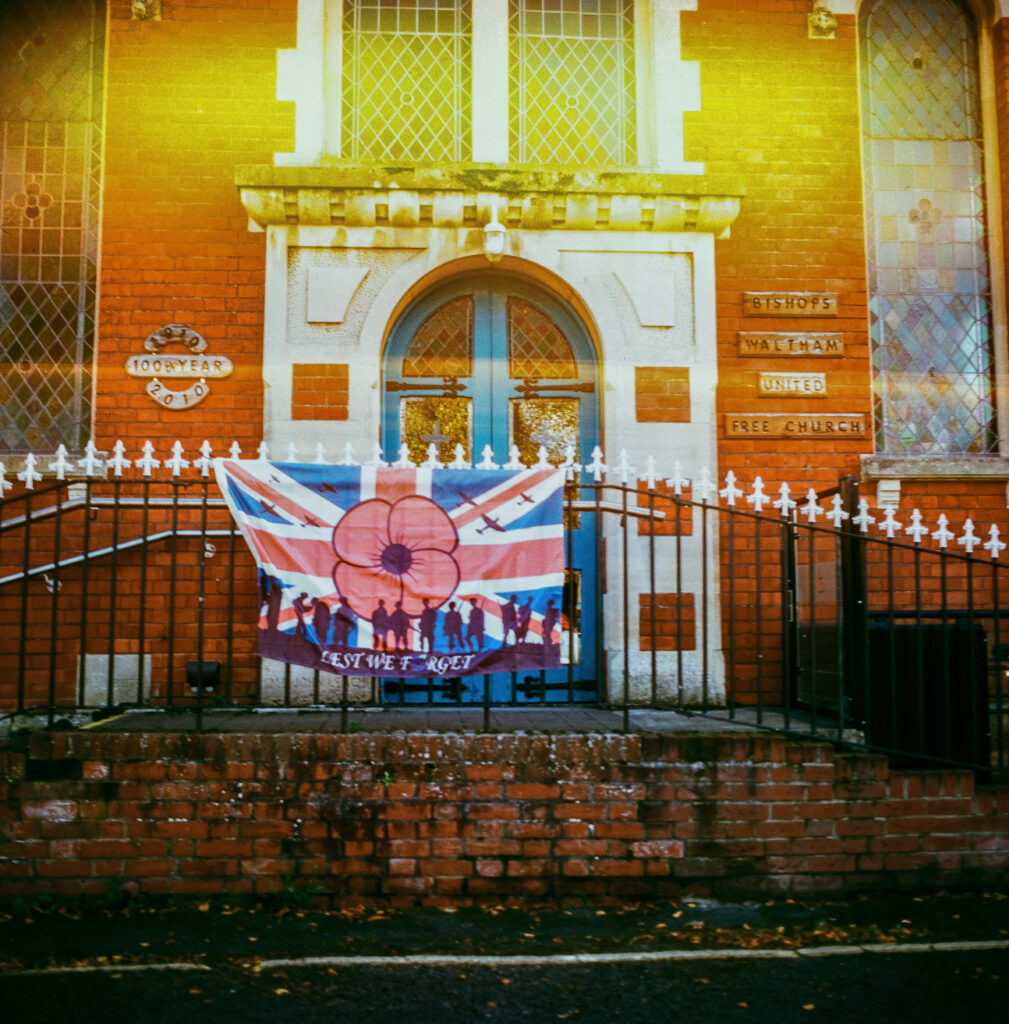 Lest we forget sign hung on the fence next to a church in Bishops Waltham
