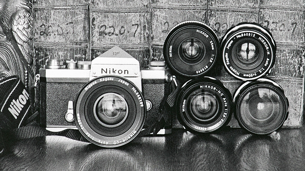 Picture of a Nikon F camera with 5 Nikkor lenses