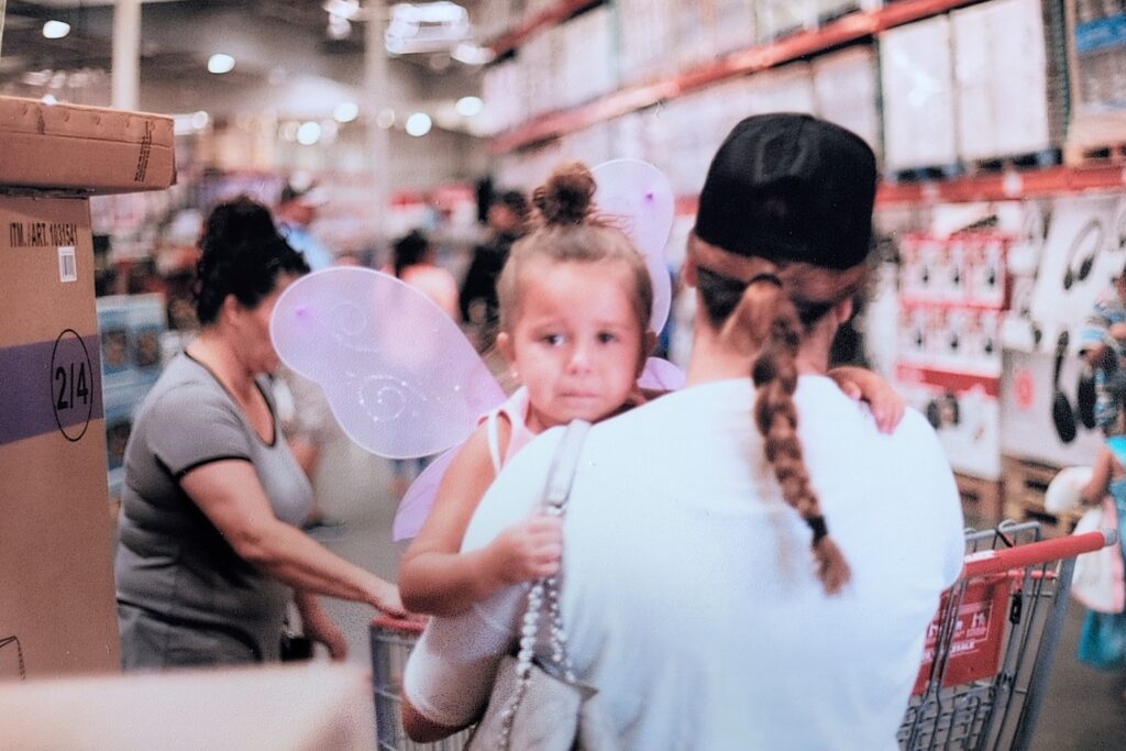 Little child being carried by mother at Costco.